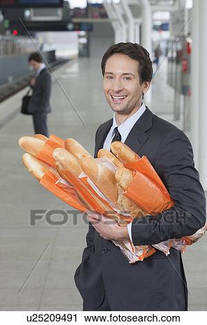 Stock Image - businessman on platform, with bread. Fotosearch