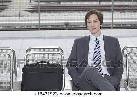 Stock Image - businessman sitting on bench, waiting. Fotosearch