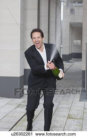 Stock Image - businessman splashing champagne. Fotosearch