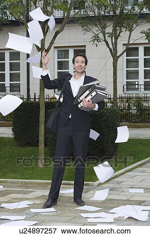 businessman surrounded by flying paper View Large Photo Image Stock Photo - businessman surrounded by flying paper. Fotosearch