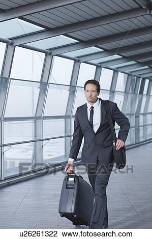 Stock Image - businessman with case walking in skywalk. Fotosearch
