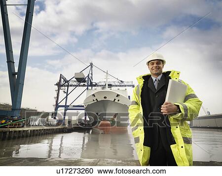 Stock Image - Businessman With Container Ship At Port. Fotosearch
