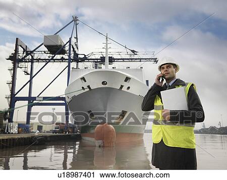 Stock Image - Businessman With Container Ship At Port. Fotosearch