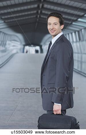 Stock Photo - businessman with laptop case, happy. Fotosearch