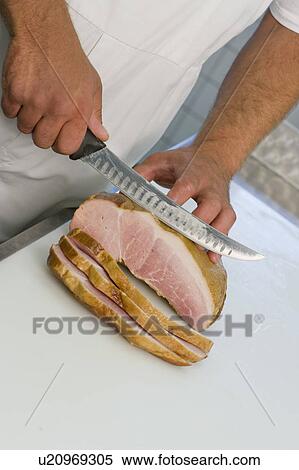Stock Photography - Butcher slicing meat. Fotosearch