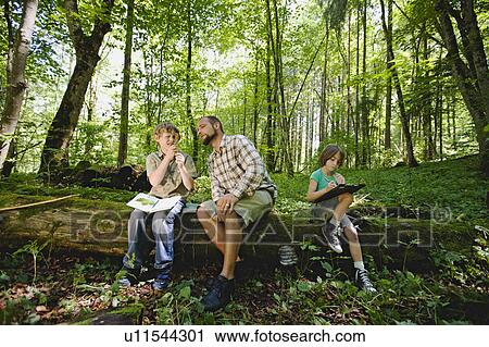 Stock Image - children and teacher in the wood. Fotosearch