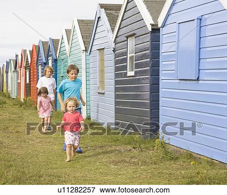 Children running past beach huts View Large Photo Image Stock Photo - Children running past beach huts. Fotosearch
