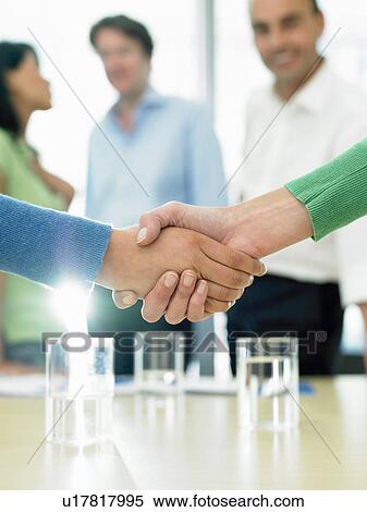 Stock Photography - Closing a business deal by shaking hands. Fotosearch