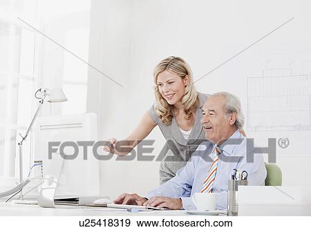 Co-workers in front of computer View Large Photo Image Stock Photo - Co-workers in front of computer. Fotosearch