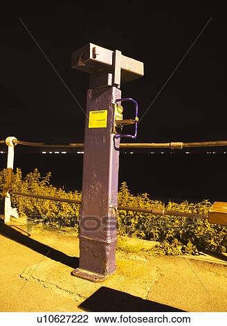 Stock Image - Coin operated telescope at night. Fotosearch