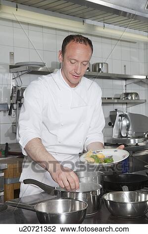 cook putting pasta into boiling water View Large Photo Image Stock Image - cook putting pasta into boiling water. Fotosearch