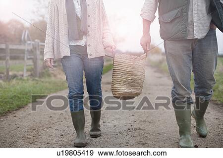 Stock Photo - couple carrying basket in countryside. Fotosearch