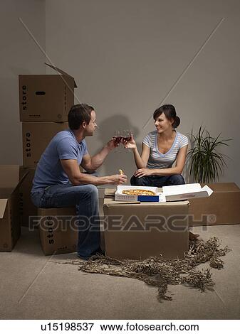 Couple eating pizza on cardboard box View Large Photo Image Stock Photo - Couple eating pizza on cardboard box. Fotosearch