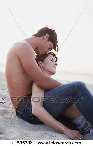 couple embracing sitting on the beach View Large Photo Image Stock Image - couple embracing sitting on the beach. Fotosearch