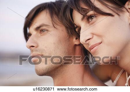 Stock Image - couple enjoying sunset on the beach. Fotosearch