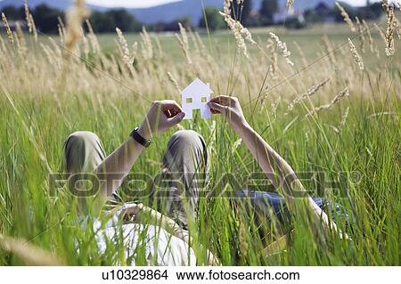 Couple holding cut-out paper houses View Large Photo Image Picture - Couple holding cut-out paper houses. Fotosearch