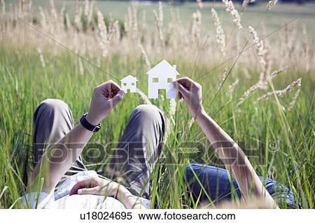 Stock Photography - Couple holding cut-out paper houses. Fotosearch