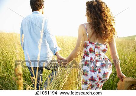 Picture - Couple holding hands in a wheat field. Fotosearch