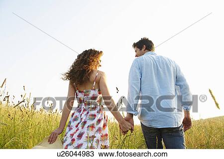 Couple holding hands in a wheat field View Large Photo Image Stock Image - Couple holding hands in a wheat field. Fotosearch
