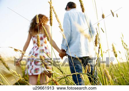 Couple holding hands in a wheat field View Large Photo Image Stock Image - Couple holding hands in a wheat field. Fotosearch