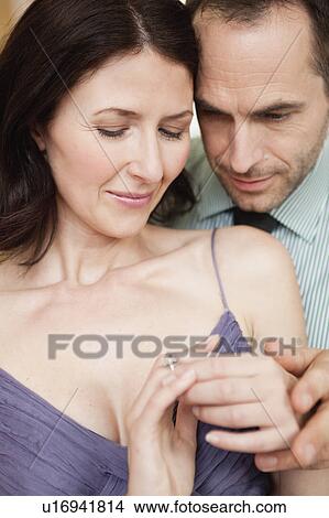 couple holding hands looking at ring View Large Photo Image Picture - couple holding hands looking at ring. Fotosearch