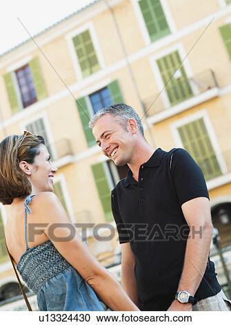Stock Image - couple holding hands smiling. Fotosearch