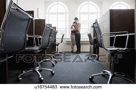 Couple hugging in a empty office View Large Photo Image Stock Image - Couple hugging in a empty office. Fotosearch