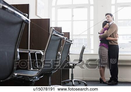 Couple hugging in a office View Large Photo Image Stock Image - Couple hugging in a office. Fotosearch