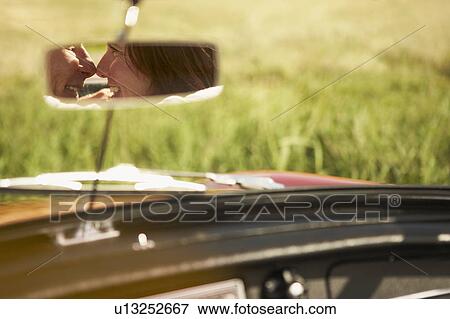 Stock Photo - Couple in rear view mirror, will kiss. Fotosearch