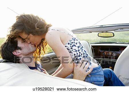 Couple kissing in a convertible View Large Photo Image Stock Image - Couple kissing in a convertible. Fotosearch
