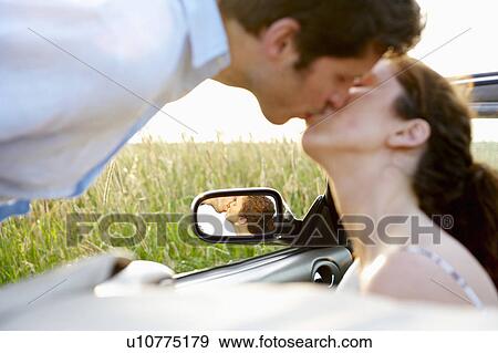 Couple kissing in a convertible View Large Photo Image Stock Photo - Couple kissing in a convertible. Fotosearch