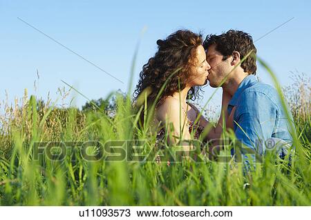 Stock Image - Couple kissing in a wheat field. Fotosearch