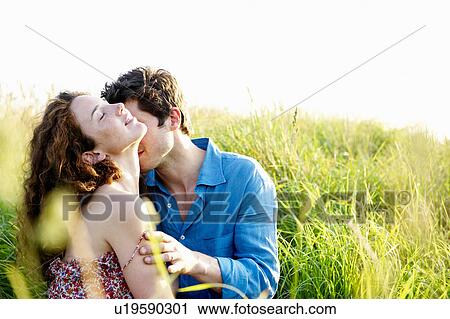 Stock Image - Couple kissing in a wheat field. Fotosearch