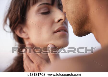 Stock Image - couple kissing on the beach. Fotosearch
