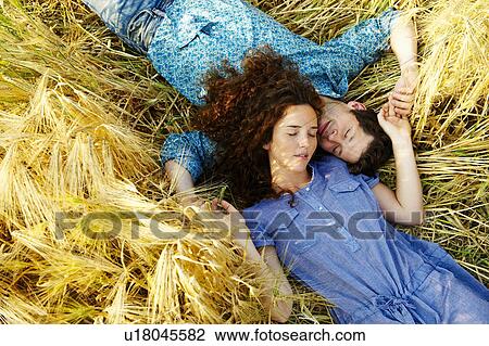Stock Image - Couple laying down in a wheat field. Fotosearch