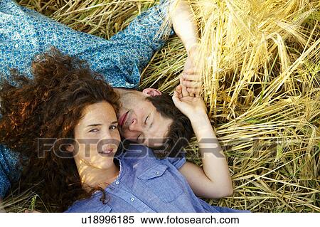 Couple laying down in a wheat field View Large Photo Image Stock Photography - Couple laying down in a wheat field. Fotosearch