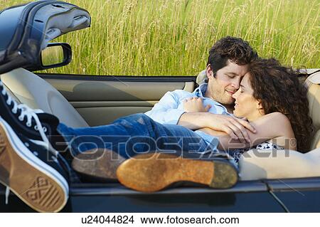 Couple laying in a convertible View Large Photo Image Picture - Couple laying in a convertible. Fotosearch
