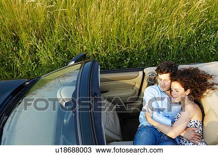 Couple laying in a convertible View Large Photo Image Stock Image - Couple laying in a convertible. Fotosearch