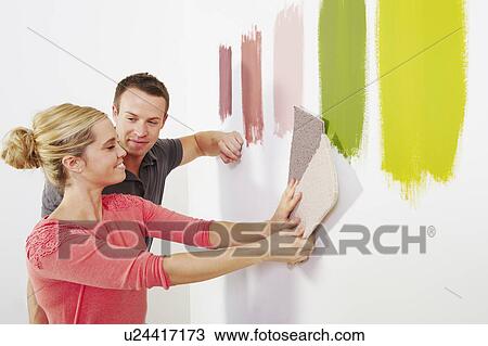 Stock Image - Couple looking at carpet samples.. Fotosearch