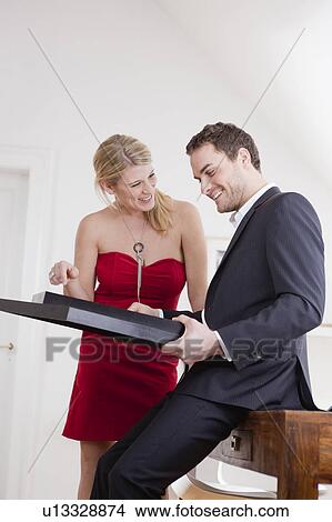 Picture - couple looking at framed pictures. Fotosearch