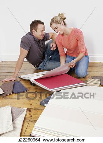 Couple looking through wallpaper books. View Large Photo Image Picture - Couple looking through wallpaper books.. Fotosearch