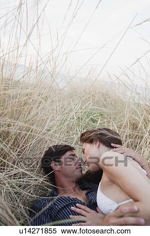 Stock Photography - couple lying in reed embracing. Fotosearch