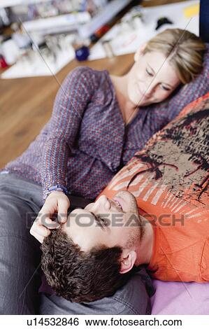 Stock Photograph - couple lying on couch caressing. Fotosearch