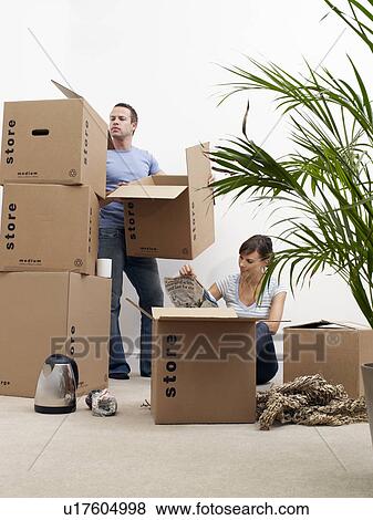 Couple moving house, unpacking boxes View Large Photo Image Stock Photo - Couple moving house, unpacking boxes. Fotosearch