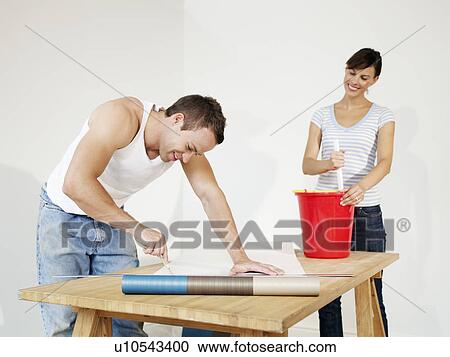 Couple preparing wallpaper View Large Photo Image Stock Image - Couple preparing wallpaper. Fotosearch