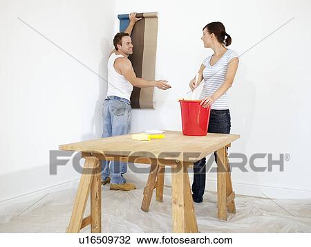Couple putting up wallpaper View Large Photo Image Stock Image - Couple putting up wallpaper. Fotosearch