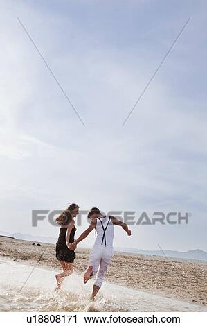 couple running along the beach View Large Photo Image Stock Image - couple running along the beach. Fotosearch