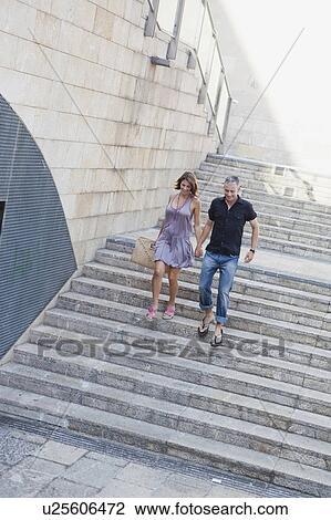 Stock Image - couple running down stairs. Fotosearch