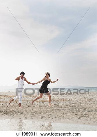 couple running on the beach View Large Photo Image Stock Image - couple running on the beach. Fotosearch