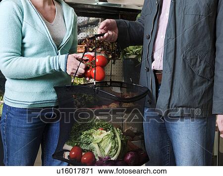 Stock Image - couple shopping for vegetables. Fotosearch
